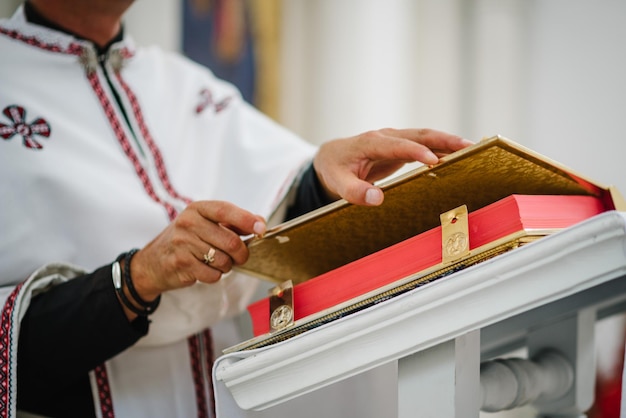 Der Priester liest eine Bibel in der Kirche Heiliges sakramentales Ereignis Nahaufnahme