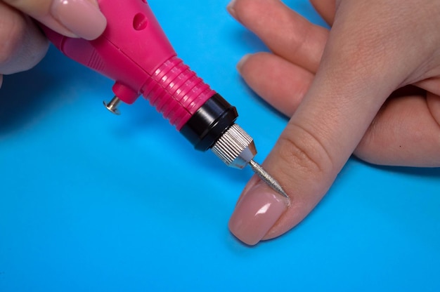 Der Prozess der Herstellung einer schönen Maniküre an den Fingern eines Fingers, der einen Nagel bearbeitet