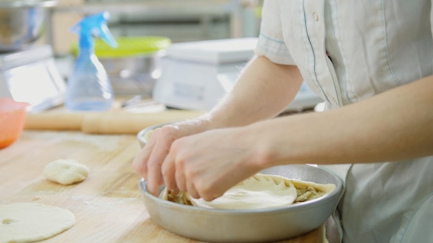 Der Prozess der Herstellung von Kuchen mit den Händen - Frau in der Bäckerei, Nahaufnahme