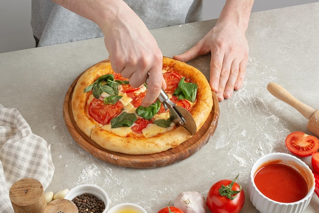 Der Prozess der Herstellung von Margarita-Pizza Männliche Hände Draufsicht Tomatenmark mit Käse