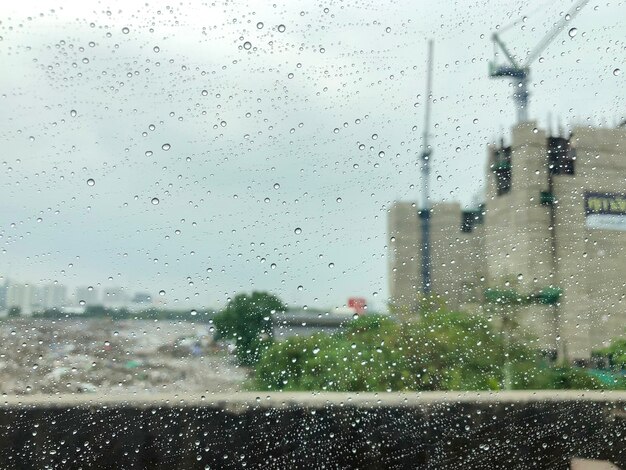 Der Regen auf Spiegelauto mit Baustellenhintergrund.