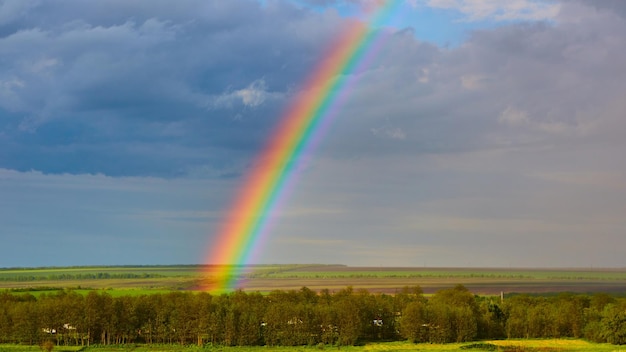 Der Regenbogen über einem Feld nach einem Gewitter