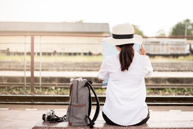 Der Rücken einer Asiatin am Bahnhof im Urlaub.