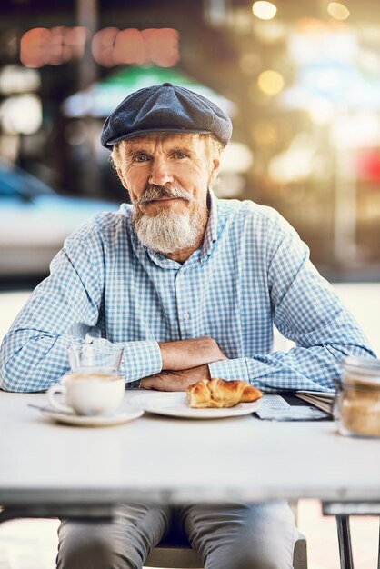 Der Ruhestand steht Ihnen gut Porträt eines glücklichen älteren Mannes, der eine Tasse Kaffee in einem Straßencafé genießt