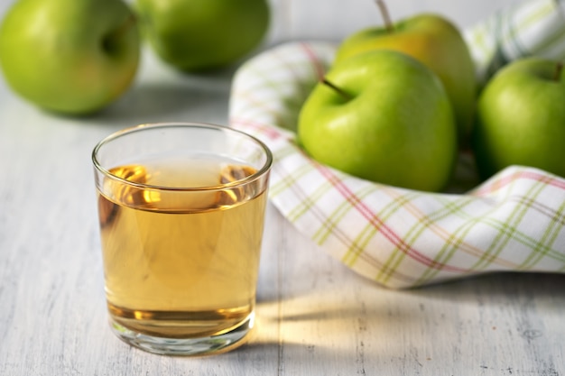 Der Saft von grünen Äpfeln in einem Glas auf einem Holztisch