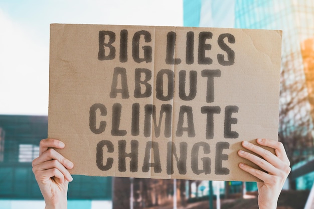 Der Satz Big liegt über den Klimawandel auf einem Banner in der Hand der Männer Propaganda Harvesting