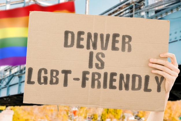 Der Satz „Denver ist LGBT-freundlich“ auf einem Banner in Männerhand mit unscharfer LGBT-Flagge im Hintergrund. Menschlichen Beziehungen. unterschiedlich. Vielfältig. Freiheit. Sexualität. Soziale Fragen. Gesellschaft