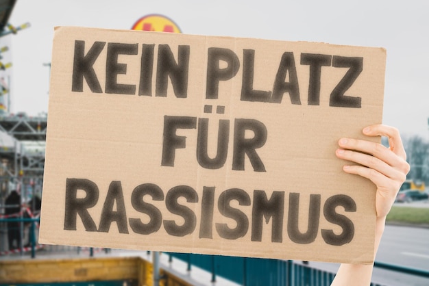 Der Satz Kein Platz für Rassismus steht auf einem Banner in den Händen der Männer mit verschwommenem Hintergrund Akzeptanz Veränderung Transformation Widerstand Opposition Trotz Demonstrant Bürger Aktivist Demokratie