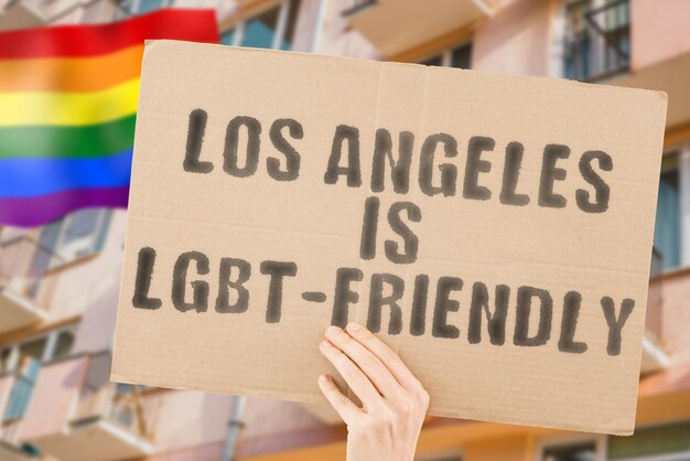 Der Satz Los Angeles ist LGBTFriendly auf einem Banner in Männerhand mit verschwommener LGBT-Flagge