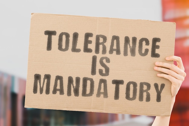 Foto der satz toleranz ist auf einem banner in männerhand mit verschwommenem hintergrund obligatorisch gleichheit