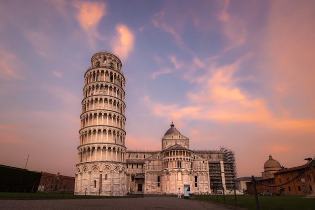 Der schiefe Turm und die Kathedrale di Pisa im goldenen Licht des Sonnenaufgangs gegen den bunten bewölkten Himmel Pisa Italien