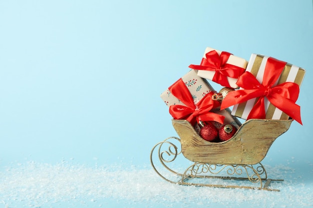 Der Schlitten des Weihnachtsmanns mit einem Haufen Geschenke auf blauem Hintergrund