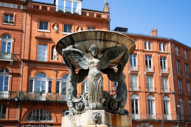 Der schöne Dreifaltigkeitsbrunnen im historischen Viertel von Toulouse mit rotem Backsteingebäude im Hintergrund Frankreich