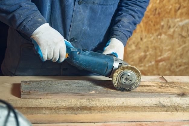 Der Schreiner fräst das Stück Holz mit einer Schleifmaschine in seiner Werkstatt