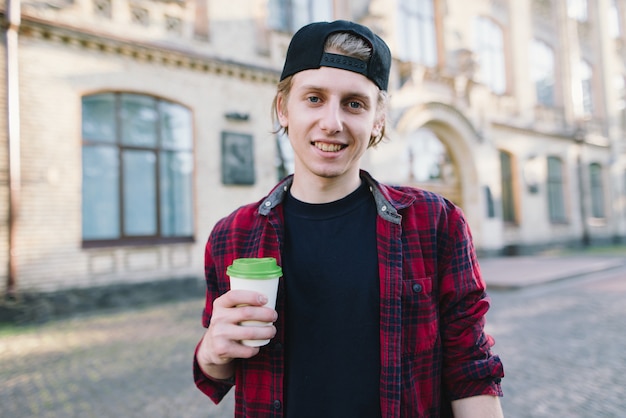 Der Schüler hält eine Tasse Kaffee in der Hand und zeigt mit dem Daumen nach oben