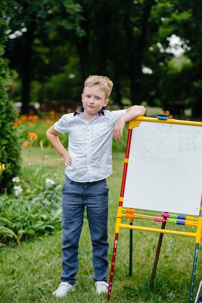 Der Schüler schreibt Unterricht an die Tafel und trainiert im Freien