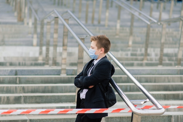 Der Schüler verlässt die Schule mit einer Schutzmaske in der Stadt