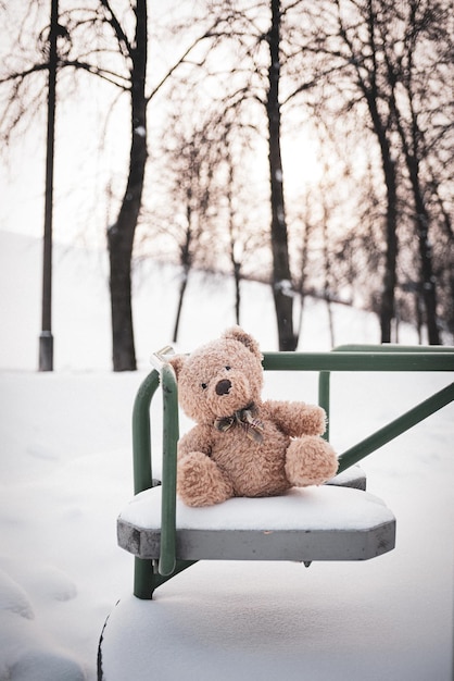 Der Spielzeugbär wurde im Winter auf dem Kinderspielplatz gelassen