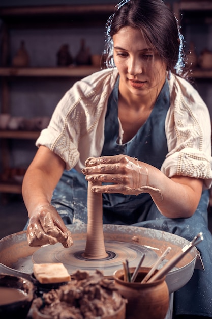 Foto der stilvolle professionelle töpfer demonstriert den prozess der herstellung von keramikgeschirr mit der alten technologie.