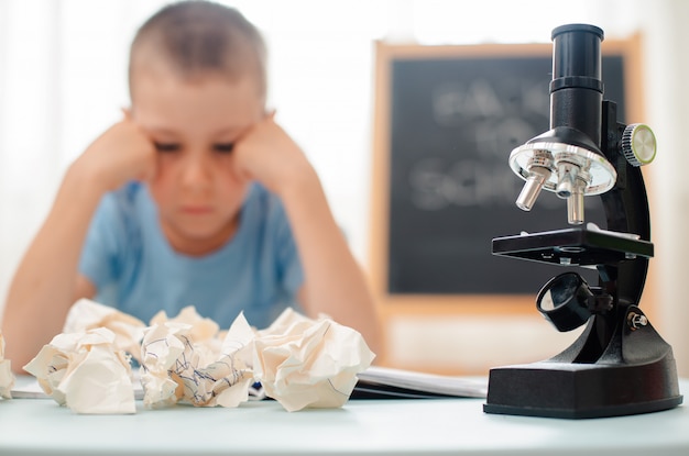 Der Student sitzt am Tisch und beschäftigt sich mit Unterrichtsmaterial