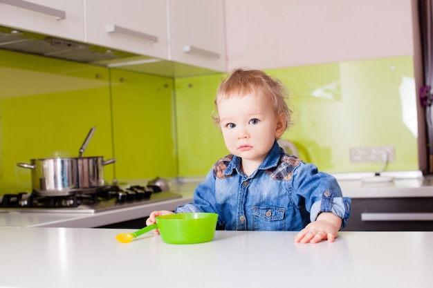 Der süße Junge bereitet sich auf das Essen vor und wartet darauf