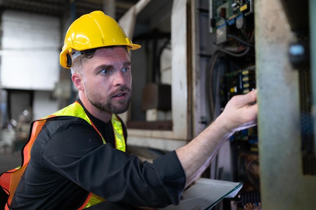 Der Techniker überprüft die Elektrik und repariert die Mechanik im Maschinenschaltschrank, damit die Maschine wieder normal läuft