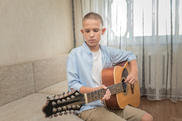 Der Teenager ist zu Hause und spielt alleine Gitarre.