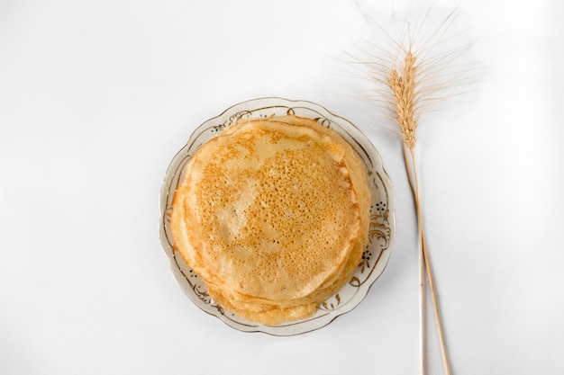 Der Teller mit Pfannkuchen und Ohr ist auf einem weißen Hintergrund isoliert.