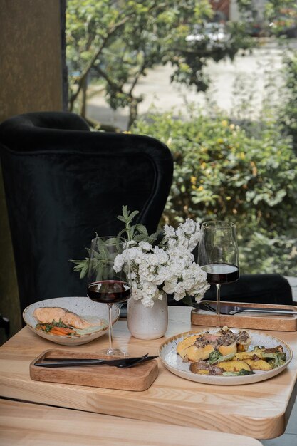 Der Tisch wird mit den Hauptgerichten und Wein in Weingläsern im Restaurant serviert