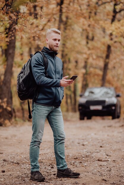 Der Tourist fährt mit dem Auto. Der Mann im Telefon sieht, wo er sich im Navigator befindet.