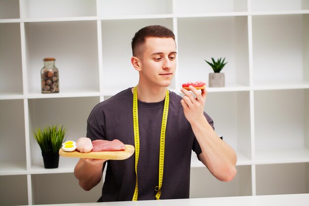 Der Trainer nimmt eine proteinreiche Mahlzeit aus Fleisch und Obst zu sich