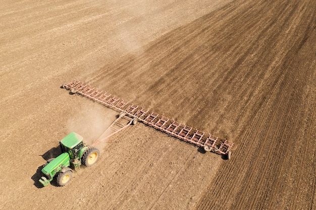 Der Traktor bearbeitet den Boden. Um die Feuchtigkeit im zeitigen Frühjahr zu speichern. Luftaufnahme.