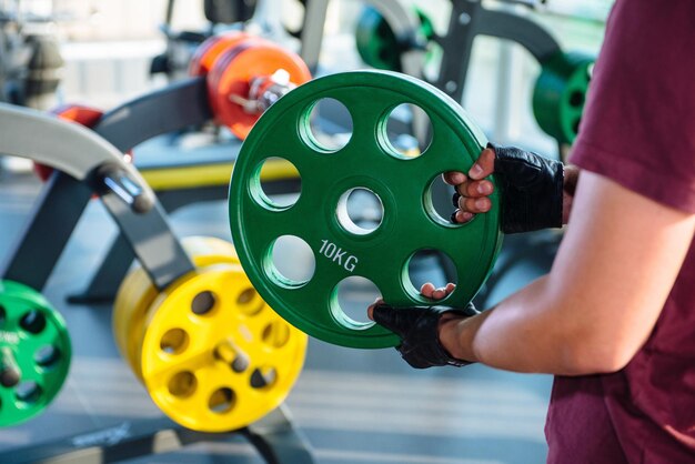 Foto der typ ändert das gewicht an einer stange im fitnessstudio