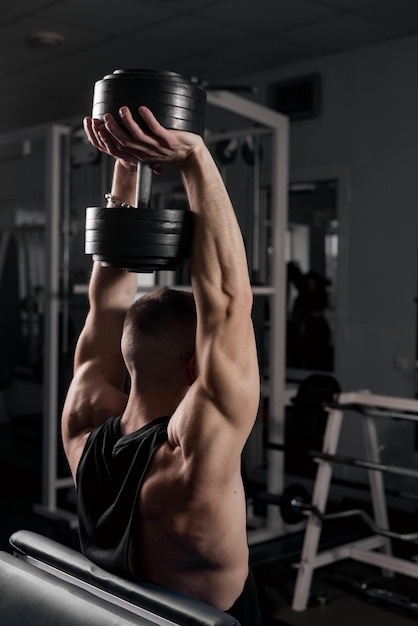 Der Typ beschäftigt sich im Fitnessstudio mit Hanteln mit dem Konzept des Sportlebens