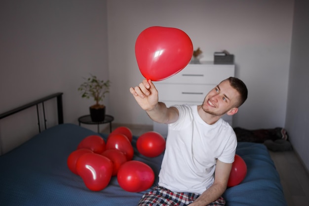 Der Typ hält einen Ballon in Form eines Herzens zum Valentinstag