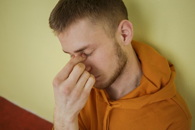 Der Typ in orangefarbener Kleidung mit blauen Augen ist traurig