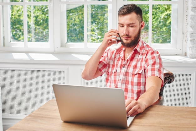 Der Typ ist ein Geschäftsmann bei der Arbeit am Schreibtisch mit Computer