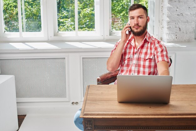 Der Typ ist ein Geschäftsmann bei der Arbeit am Schreibtisch mit Computer