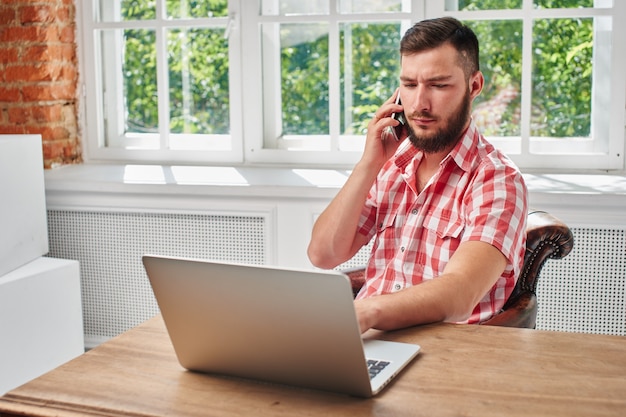 Der Typ ist ein Geschäftsmann bei der Arbeit am Schreibtisch mit Computer