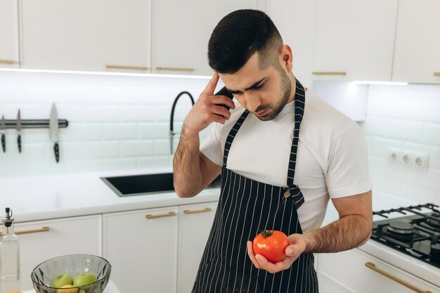 Der Typ kocht in seiner Küche. Er überlegt, was er mit Gemüse kochen soll