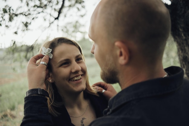 Der Typ legt Blumen in das Haar ihres Geliebten