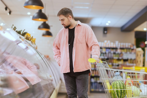 Der Typ macht Einkäufe im Supermarkt das Konzept des Einkaufens