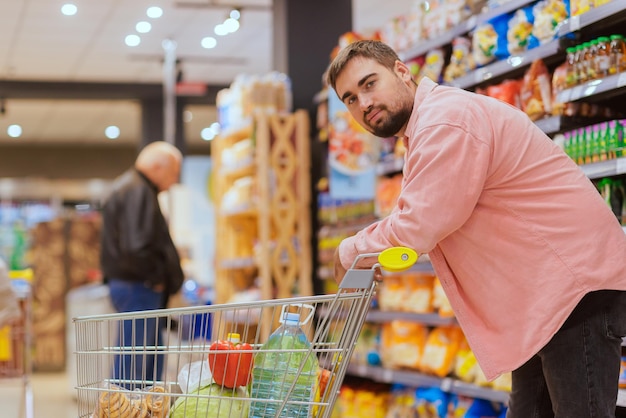 Der Typ macht Einkäufe im Supermarkt das Konzept des Einkaufens