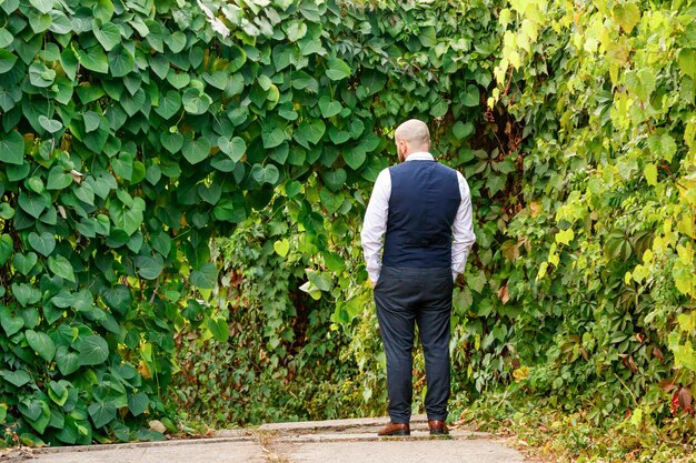 Der Typ steht mit dem Rücken im Park