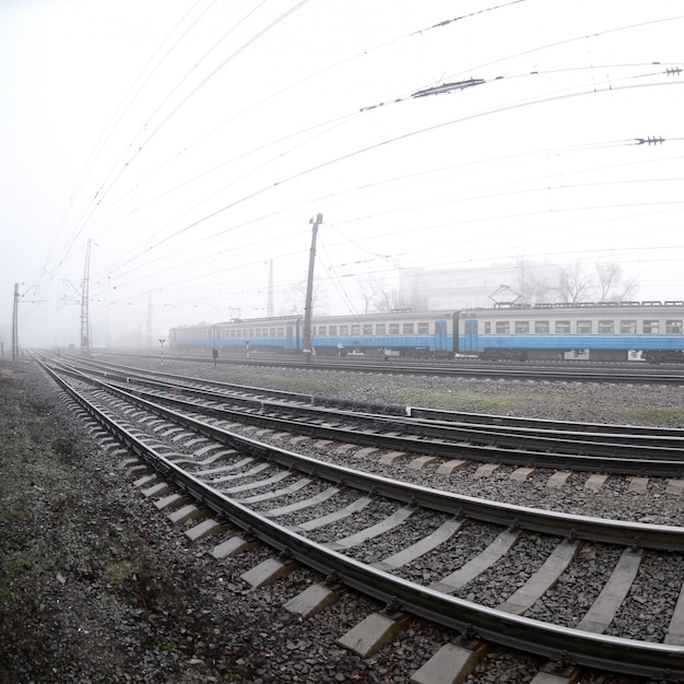 Der ukrainische Nahverkehrszug eilt an einem nebligen Morgen entlang der Eisenbahn