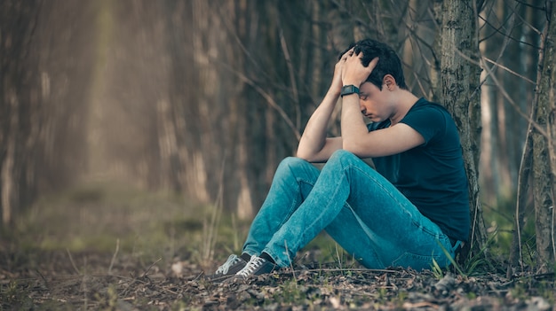 Der unglückliche Mann im Wald leidet unter Depressionen und Frustration des Lebens. Speicherplatz kopieren