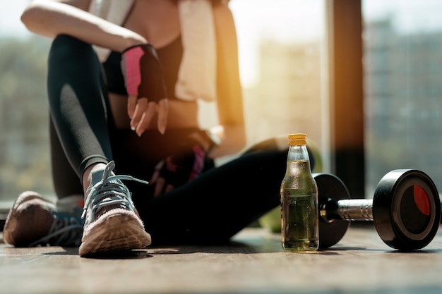 Foto der untere teil einer frau, die im fitnessstudio sitzt