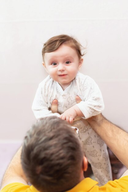 Der Vater hält das Kind über sich