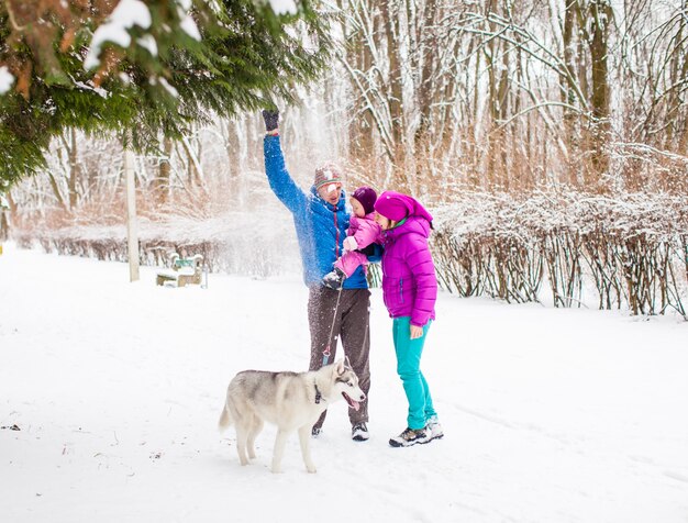 Der Vater zeigt seiner entzückenden kleinen Tochter einen Schneefall, einen verschneiten Wintertag