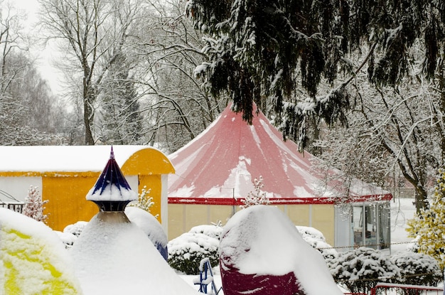 Der Vergnügungspark ist geschlossen Es ist Winter und sehr kalt Alles ist mit Schnee bedeckt Tannenzweige hängen über der Zirkuskuppel